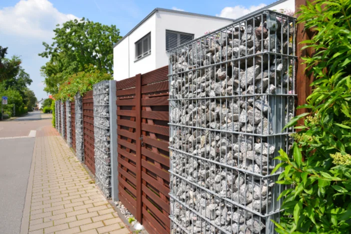 Gartenzaun aus Holz und Gabionen